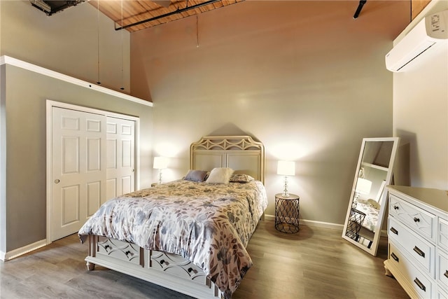 1117 Douglas Ave Unit 124, North Providence, RI 02904 - bedroom featuring a wall mounted AC, wood finished floors, wood ceiling, and a towering ceiling