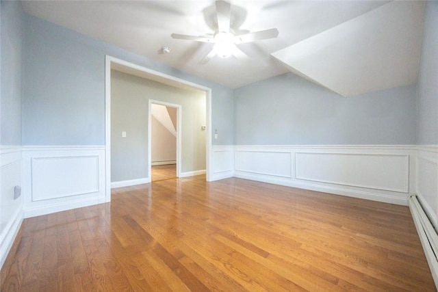 193 Howell St Unit 3, Providence, RI 02906 - additional living space featuring a baseboard heating unit, wood finished floors, a ceiling fan, a wainscoted wall, and a decorative wall