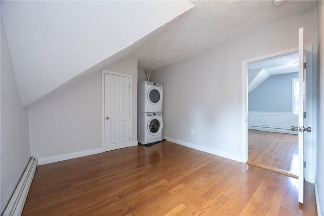 193 Howell St Unit 3, Providence, RI 02906 - additional living space with baseboard heating, estacked washer and dryer, wood finished floors, and vaulted ceiling