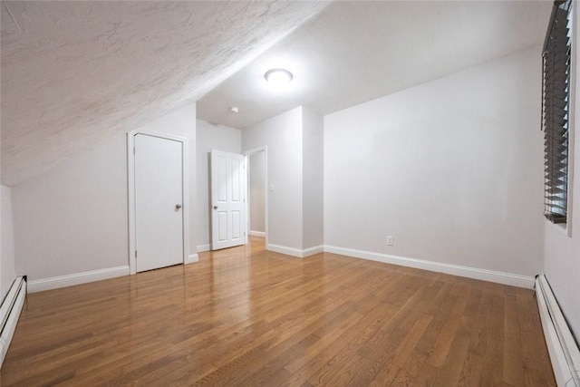 193 Howell St Unit 3, Providence, RI 02906 - bonus room featuring baseboard heating, wood finished floors, vaulted ceiling, and a textured ceiling