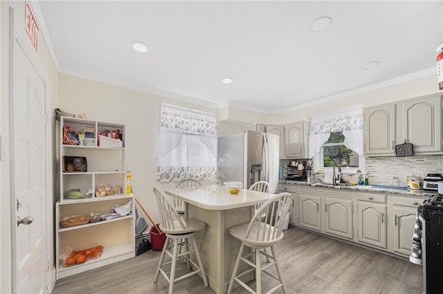 236 Vermont Ave, Providence, RI 02905 - kitchen with stainless steel appliances, a kitchen bar, light wood-style flooring, backsplash, and light countertops