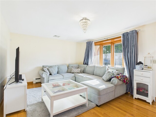 128 Arbor Ter, Tiverton, RI 02878 - living room with a baseboard heating unit, light wood-style floors, and a chandelier
