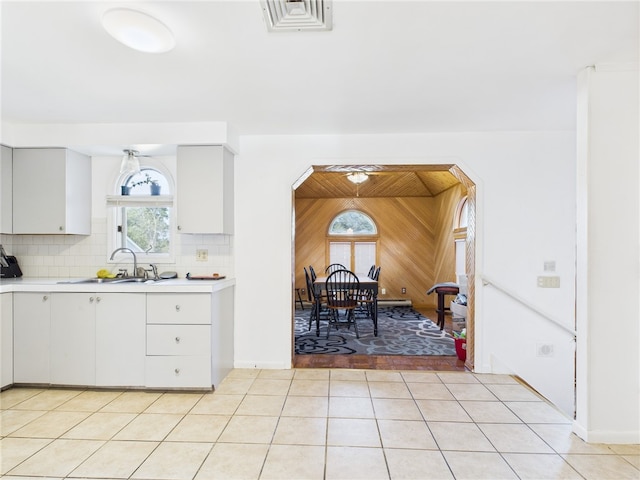 128 Arbor Ter, Tiverton, RI 02878 - kitchen featuring light countertops, arched walkways, tasteful backsplash, white cabinetry, and light tile patterned floors