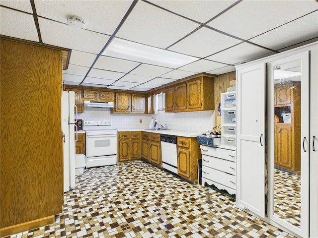 128 Arbor Ter, Tiverton, RI 02878 - kitchen featuring white appliances, under cabinet range hood, tile patterned floors, a paneled ceiling, and brown cabinets