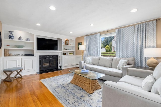 57 Hillside Rd, Lincoln, RI 02865 - living room featuring a fireplace with flush hearth, light wood-type flooring, a baseboard heating unit, recessed lighting, and built in shelves