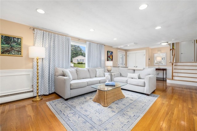 57 Hillside Rd, Lincoln, RI 02865 - living area with baseboard heating, stairs, light wood finished floors, a wainscoted wall, and recessed lighting