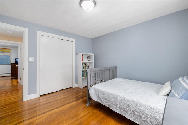 57 Hillside Rd, Lincoln, RI 02865 - bedroom featuring a baseboard heating unit, wood finished floors, and a closet