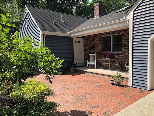 2 Marywood Ln, Cumberland, RI 02864 - property entrance featuring a chimney, brick siding, and a shingled roof