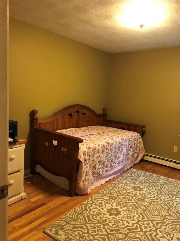 2 Marywood Ln, Cumberland, RI 02864 - bedroom with wood finished floors and a baseboard heating unit