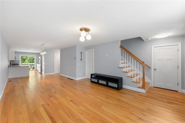1 Lily Ln Unit 1, West Warwick, RI 02893 - unfurnished living room featuring light wood-type flooring and stairs
