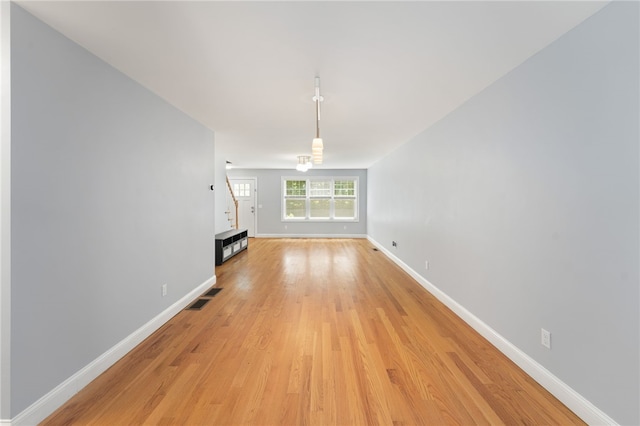 1 Lily Ln Unit 1, West Warwick, RI 02893 - unfurnished living room featuring stairway and light wood-style floors
