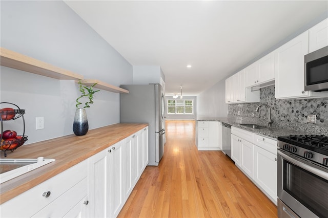 1 Lily Ln Unit 1, West Warwick, RI 02893 - kitchen featuring stainless steel appliances, open shelves, backsplash, white cabinetry, and light wood-type flooring