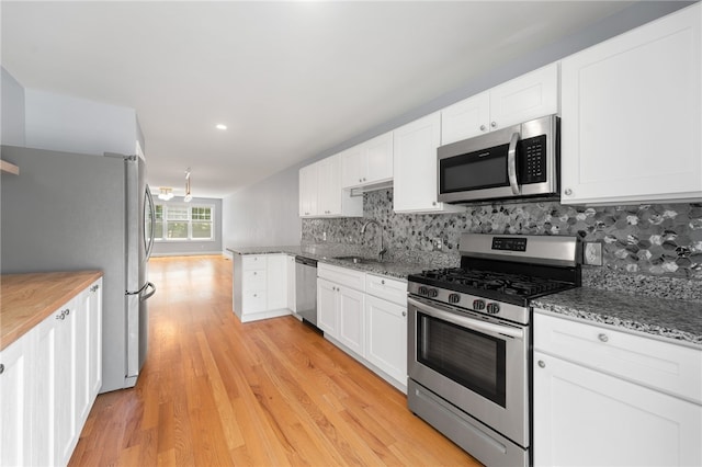 1 Lily Ln Unit 1, West Warwick, RI 02893 - kitchen with stainless steel appliances, tasteful backsplash, white cabinets, light wood-type flooring, and recessed lighting