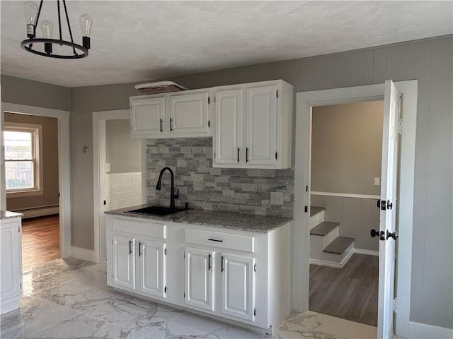 784 York Ave, Pawtucket, RI 02861 - kitchen featuring a baseboard radiator, white cabinets, backsplash, light marble finish flooring, and light stone counters