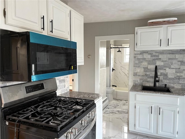 784 York Ave, Pawtucket, RI 02861 - kitchen with stainless steel range with gas stovetop, black microwave, light marble finish flooring, backsplash, and white cabinetry