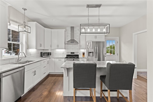 15 Mathew Rd, Tiverton, RI 02878 - kitchen featuring appliances with stainless steel finishes, wall chimney exhaust hood, tasteful backsplash, light stone countertops, and a center island