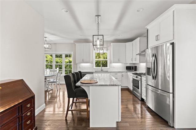 15 Mathew Rd, Tiverton, RI 02878 - kitchen featuring appliances with stainless steel finishes, decorative backsplash, dark wood finished floors, a breakfast bar, and a kitchen island