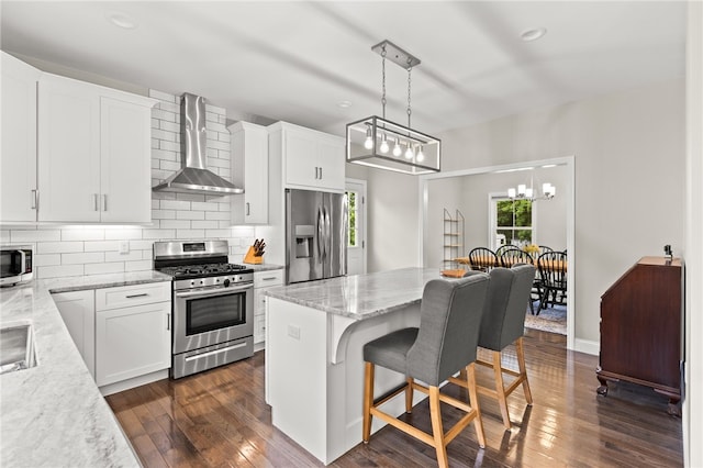 15 Mathew Rd, Tiverton, RI 02878 - kitchen featuring appliances with stainless steel finishes, wall chimney exhaust hood, a kitchen bar, decorative backsplash, and a kitchen island