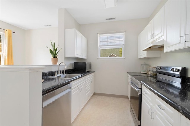 112 Mill St Unit 203, Woonsocket, RI 02895 - kitchen with stainless steel appliances, under cabinet range hood, and white cabinets