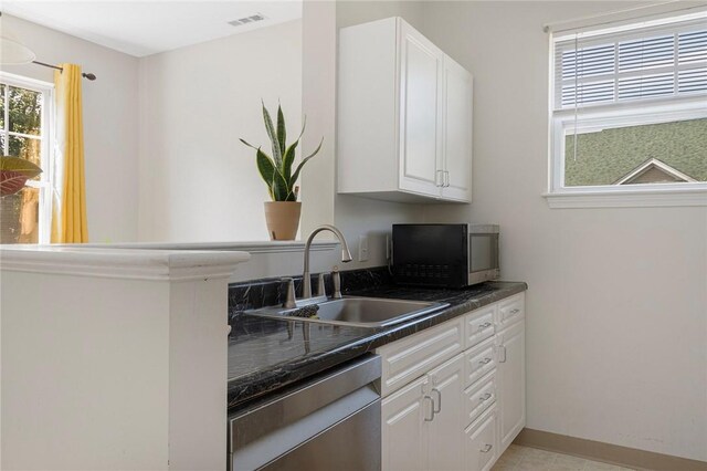 112 Mill St Unit 203, Woonsocket, RI 02895 - kitchen with dishwasher, dark countertops, white cabinetry, and light tile patterned floors
