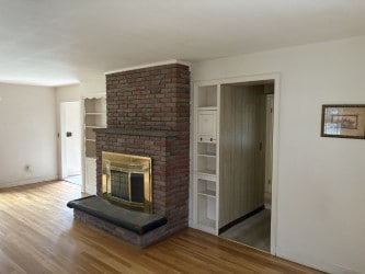 10 Jesse Davis Ln, Barrington, RI 02806 - unfurnished living room with wood finished floors and a fireplace