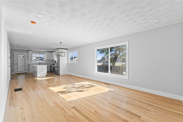 3 Riverview Ave, Westerly, RI 02891 - unfurnished living room featuring baseboards and light wood-type flooring