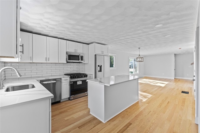 3 Riverview Ave, Westerly, RI 02891 - kitchen featuring appliances with stainless steel finishes, decorative backsplash, white cabinetry, and a center island