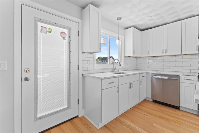 3 Riverview Ave, Westerly, RI 02891 - kitchen with dishwasher, white cabinets, light wood-type flooring, tasteful backsplash, and hanging light fixtures