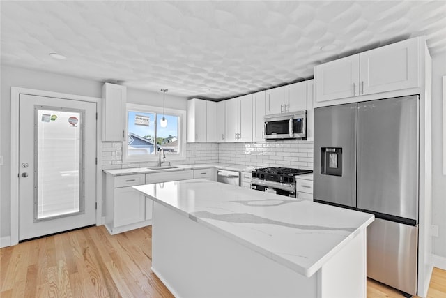 3 Riverview Ave, Westerly, RI 02891 - kitchen with stainless steel appliances, white cabinetry, light stone counters, and decorative backsplash