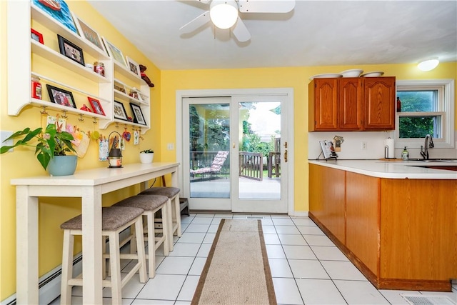 65 Jeri Lynn Cir, Warwick, RI 02886 - kitchen with light countertops, plenty of natural light, a ceiling fan, and brown cabinets