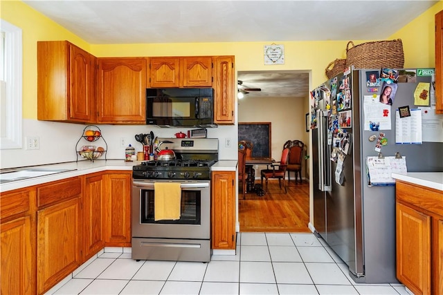 65 Jeri Lynn Cir, Warwick, RI 02886 - kitchen with appliances with stainless steel finishes, brown cabinetry, light countertops, and a ceiling fan