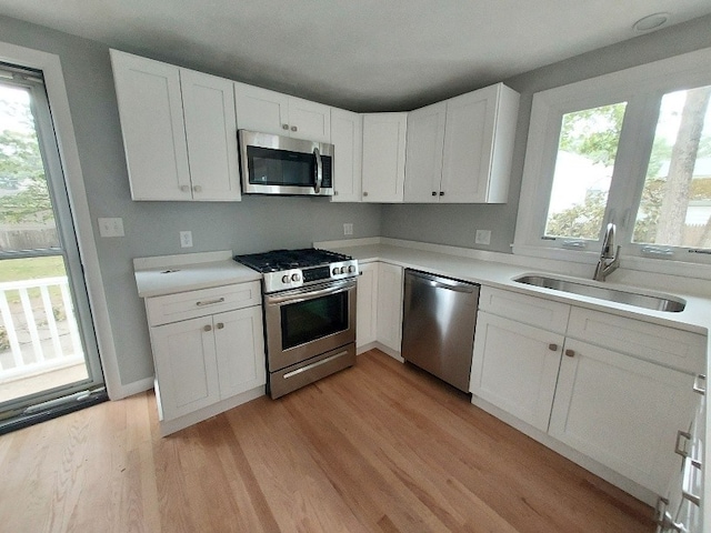 16 Fyffe Ave, Cranston, RI 02920 - kitchen featuring appliances with stainless steel finishes, plenty of natural light, light wood-type flooring, and white cabinetry
