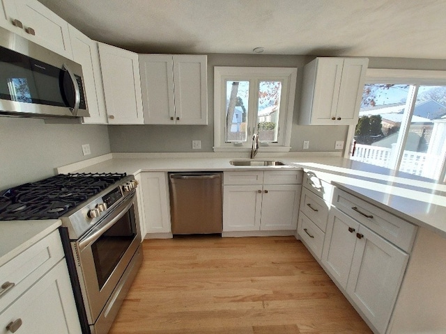 16 Fyffe Ave, Cranston, RI 02920 - kitchen featuring stainless steel appliances, white cabinets, light wood-style floors, and light countertops