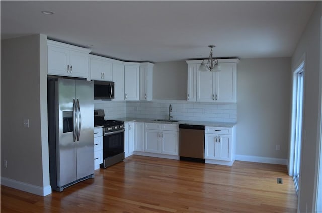 68 Greene St Unit 5, Warwick, RI 02886 - kitchen featuring stainless steel appliances, backsplash, and white cabinets