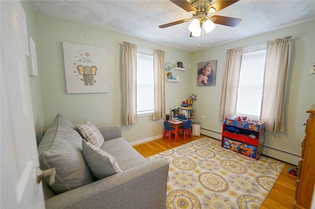 14 Willow Dr, Cranston, RI 02920 - living area with a baseboard radiator, wood finished floors, and ceiling fan