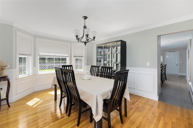 32 Susan Dr, Cumberland, RI 02864 - dining room featuring a chandelier, light wood-style floors, a decorative wall, crown molding, and wainscoting