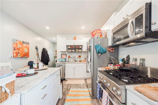 15 Wendell St, Providence, RI 02909 - kitchen with appliances with stainless steel finishes, white cabinetry, light wood-style floors, light stone countertops, and recessed lighting