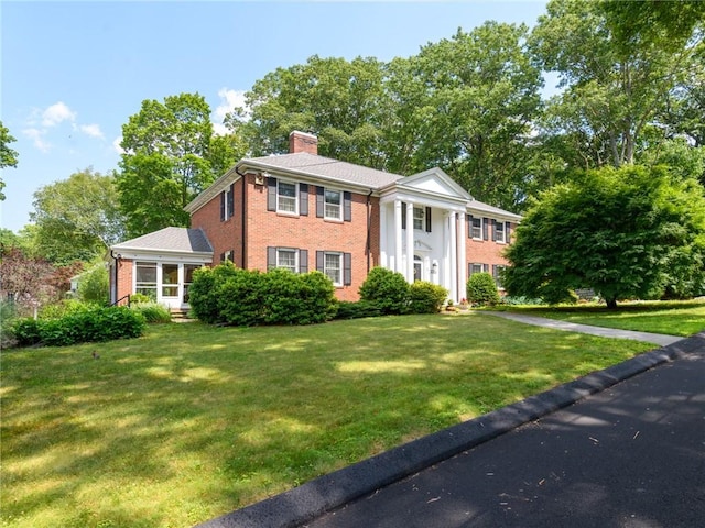 173 Gaskill St, Woonsocket, RI 02895 - neoclassical home with a chimney, brick siding, and a front yard