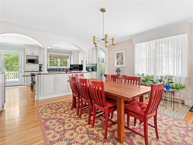 173 Gaskill St, Woonsocket, RI 02895 - dining space featuring crown molding, arched walkways, light wood finished floors, and healthy amount of natural light