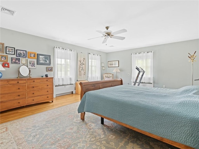 173 Gaskill St, Woonsocket, RI 02895 - bedroom featuring multiple windows, wood finished floors, ceiling fan, and radiator heating unit