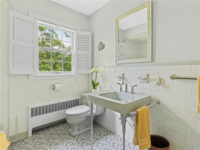 173 Gaskill St, Woonsocket, RI 02895 - bathroom with radiator heating unit, tile walls, and a wainscoted wall