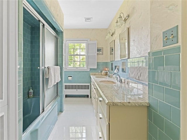 173 Gaskill St, Woonsocket, RI 02895 - bathroom with radiator heating unit, tile patterned flooring, tile walls, double vanity, and shower / bath combination with glass door