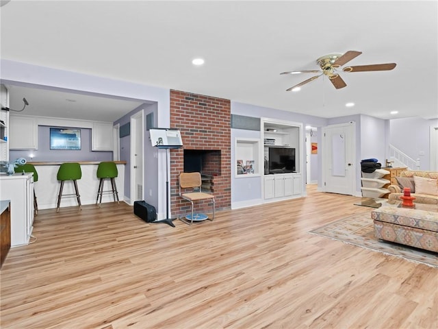 173 Gaskill St, Woonsocket, RI 02895 - living room with light wood-style floors, built in features, a ceiling fan, and a fireplace
