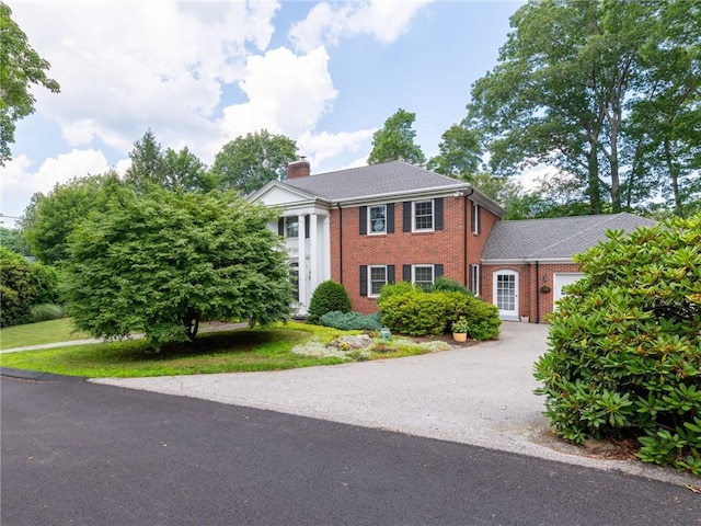 173 Gaskill St, Woonsocket, RI 02895 - neoclassical / greek revival house featuring asphalt driveway, brick siding, an attached garage, and a chimney