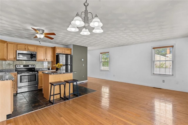 1 Lisi Ln Unit 1, Providence, RI 02904 - kitchen with stainless steel appliances, a kitchen island, dark wood-style flooring, a kitchen bar, and a chandelier