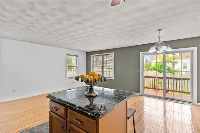 1 Lisi Ln Unit 1, Providence, RI 02904 - kitchen featuring wood finished floors, a chandelier, a breakfast bar, a center island, and a textured ceiling
