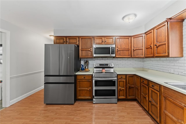 85 N Cobble Hill Rd, Warwick, RI 02886 - kitchen featuring stainless steel appliances, brown cabinets, light countertops, and tasteful backsplash