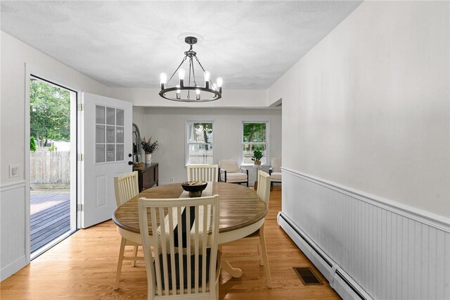 188 Reynolds Ave, Warwick, RI 02889 - dining room with a chandelier, a baseboard heating unit, plenty of natural light, light wood-type flooring, and wainscoting