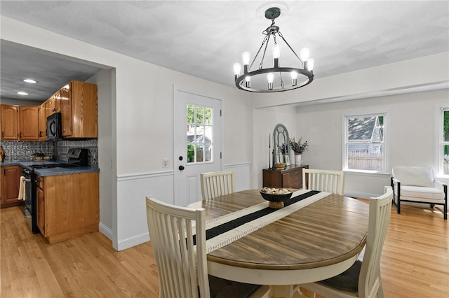 188 Reynolds Ave, Warwick, RI 02889 - dining area with a chandelier, light wood-type flooring, and a wainscoted wall