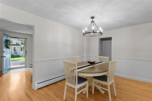 188 Reynolds Ave, Warwick, RI 02889 - dining space featuring baseboard heating, light wood-style floors, a chandelier, a wainscoted wall, and a baseboard heating unit